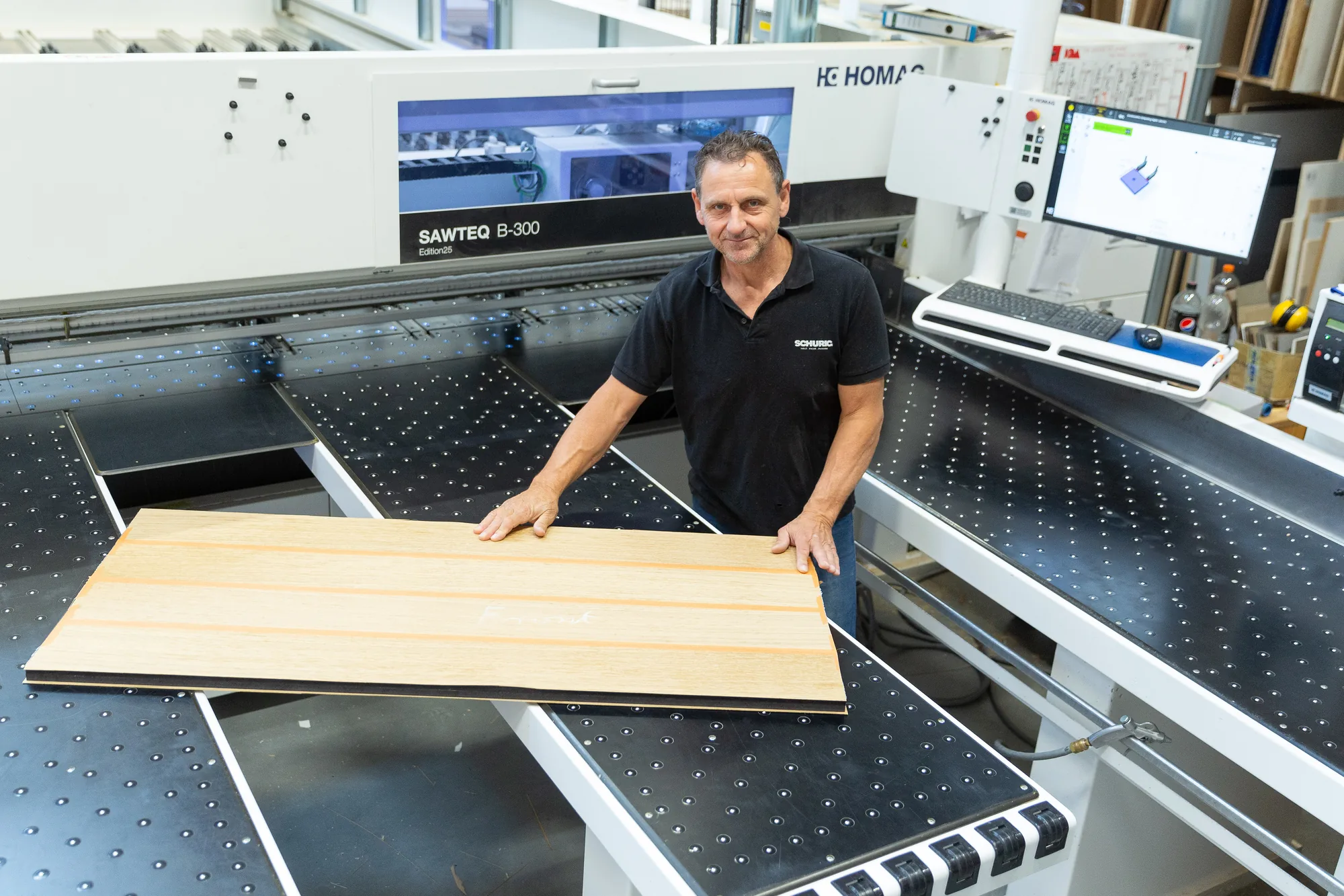 Zuschnitt einer furnierten Platte an der Plattenaufteilsäge der Schreinerei Schurig