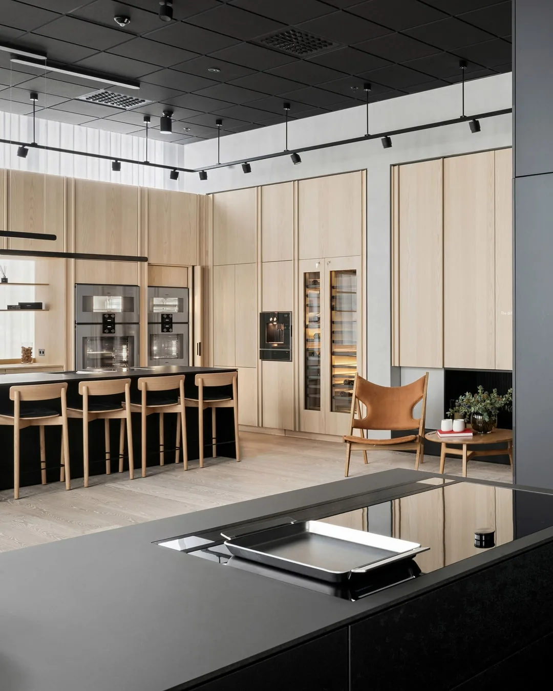 Showroom in Oslo mit raumhoher Wand aus Esche und Kochinsel, Innenausbau der Schreinerei Schurig